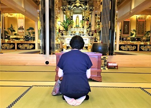 A woman worshipping in front of Buddha statue