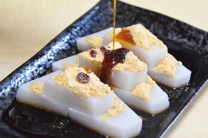 Kuzu-mochi with soybean flour pouring brown syrup
